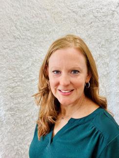Connie Weaver in front of a white wall. 