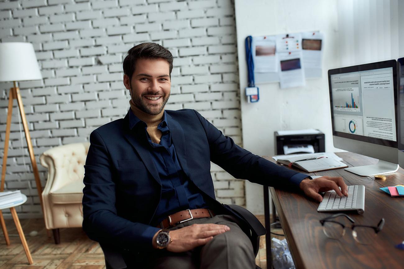 Man in blue sport coat sitting at his desk reviewing a professional development course