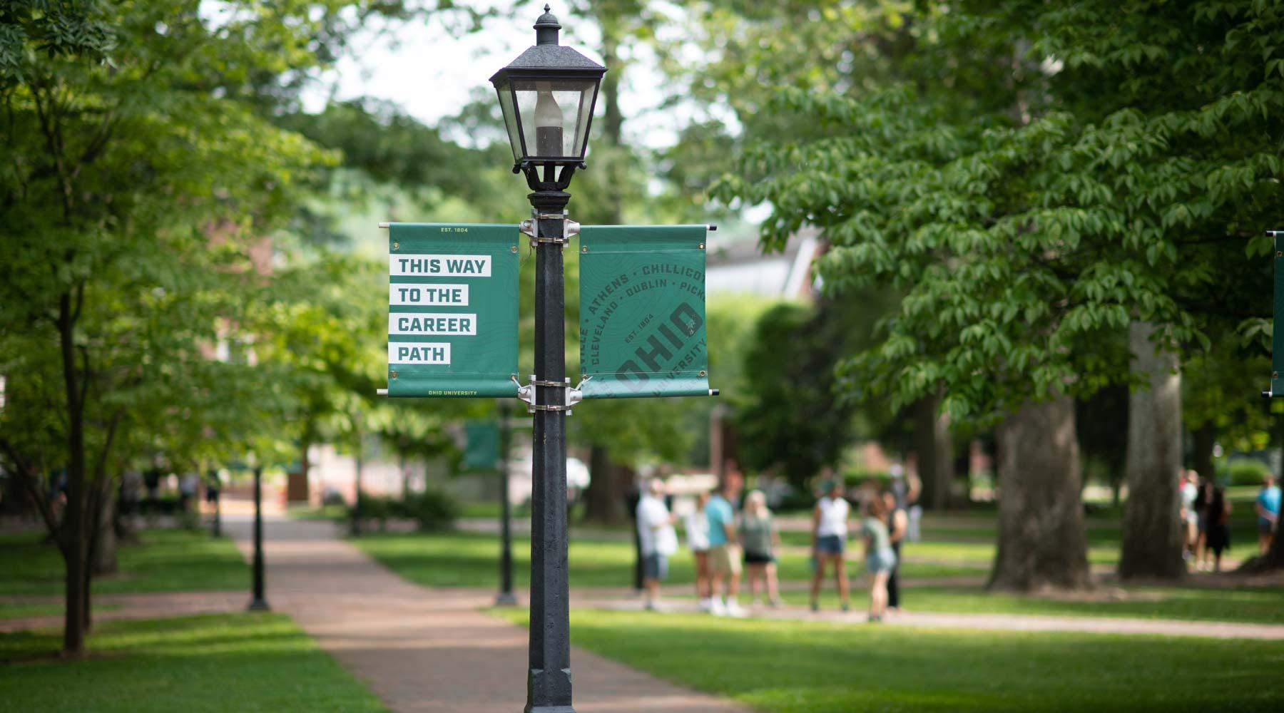 Lampost with green flag sign stating "this way to career path" on walkway