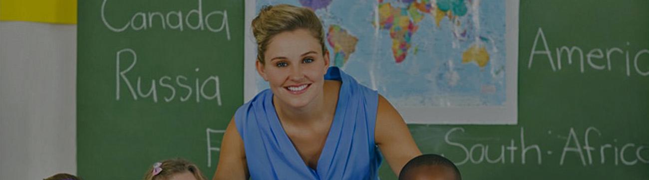 A teacher with a global map on her blackboard