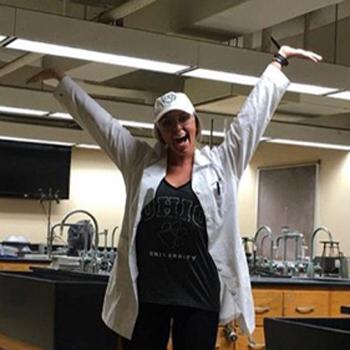 Chemistry alumna Chelsea Lang holds her hands high.