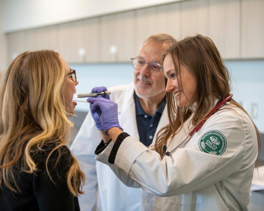 Physician Assistant student examines a patient's mouth