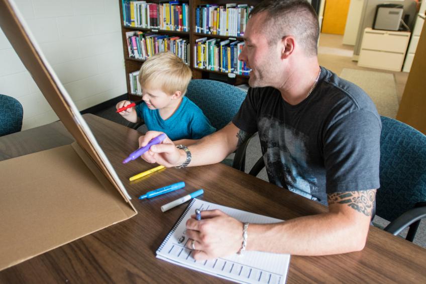 Social work student works with a child in a counseling session