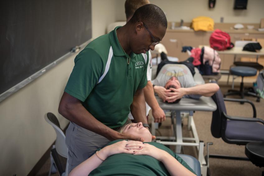 Physical therapy student manipulates a patient's neck