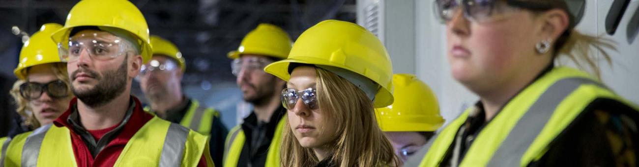 Group of people in hard hats and high-vis vests on a job site