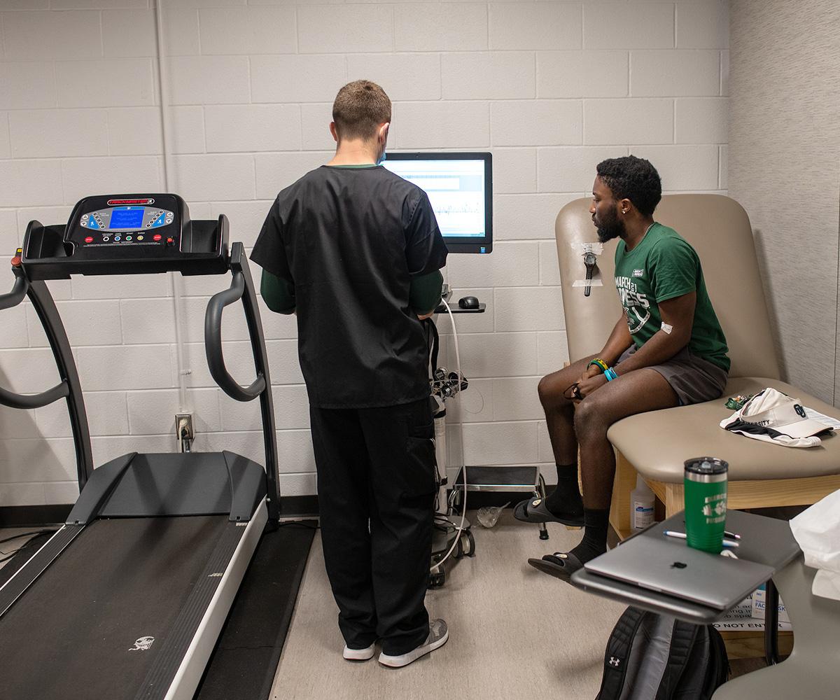 An exercise physiology student conducts a test with a patient.