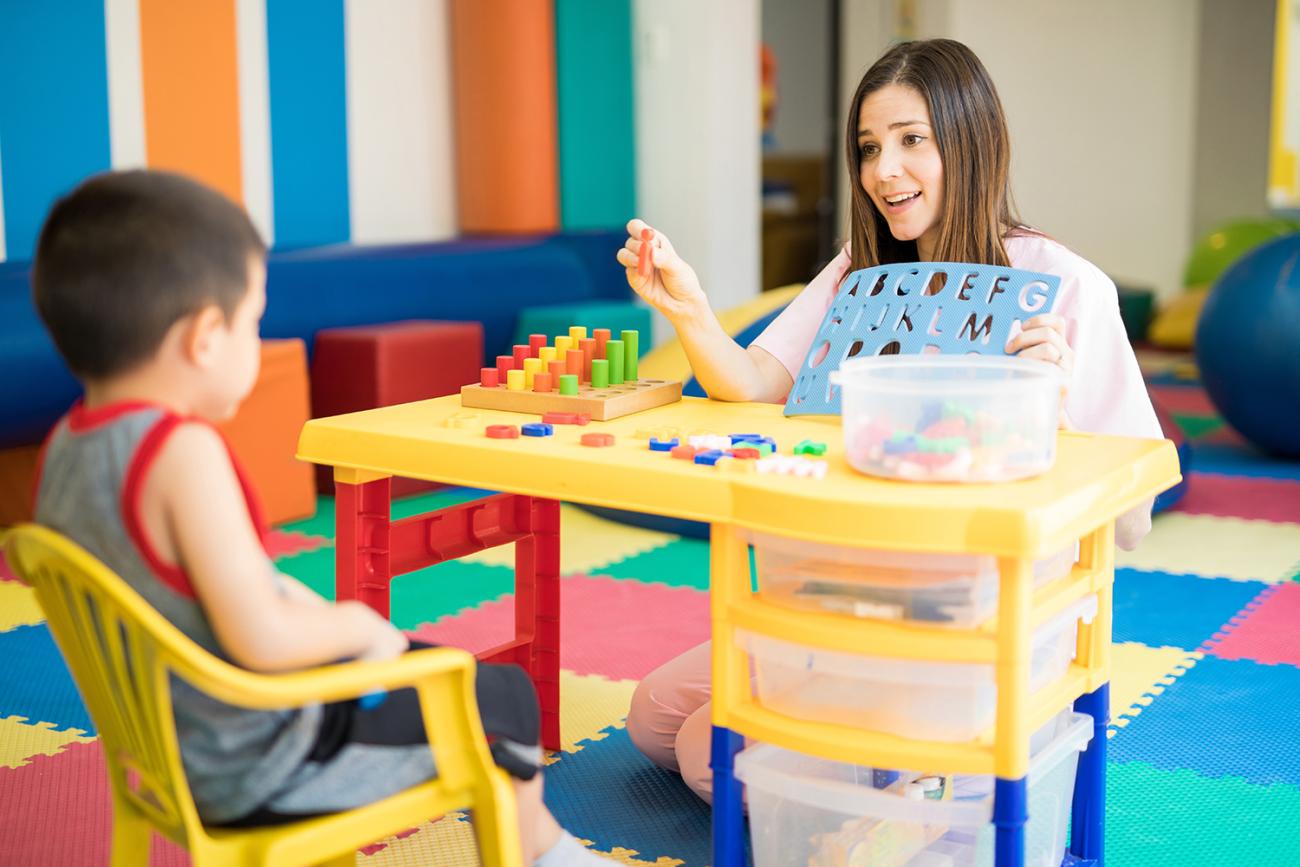 Teacher holding up an alphabet teaching tool.