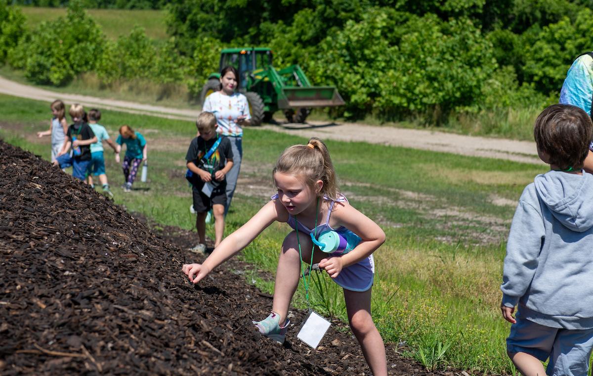 Young girl climbing a mulch pile at OHIO's Compost Facility in 2024