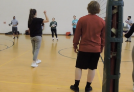 Faculty talking to a volleyball class
