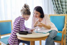 Adult counselor talking to a young teenage girl.