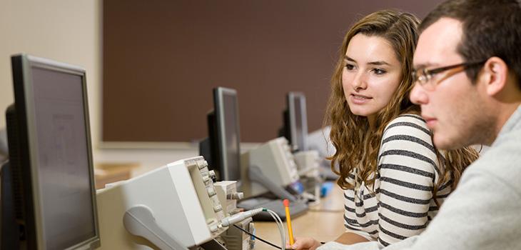 Man and woman looking at a computer monitor