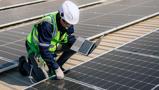 Civil engineer kneeling beside solar panels