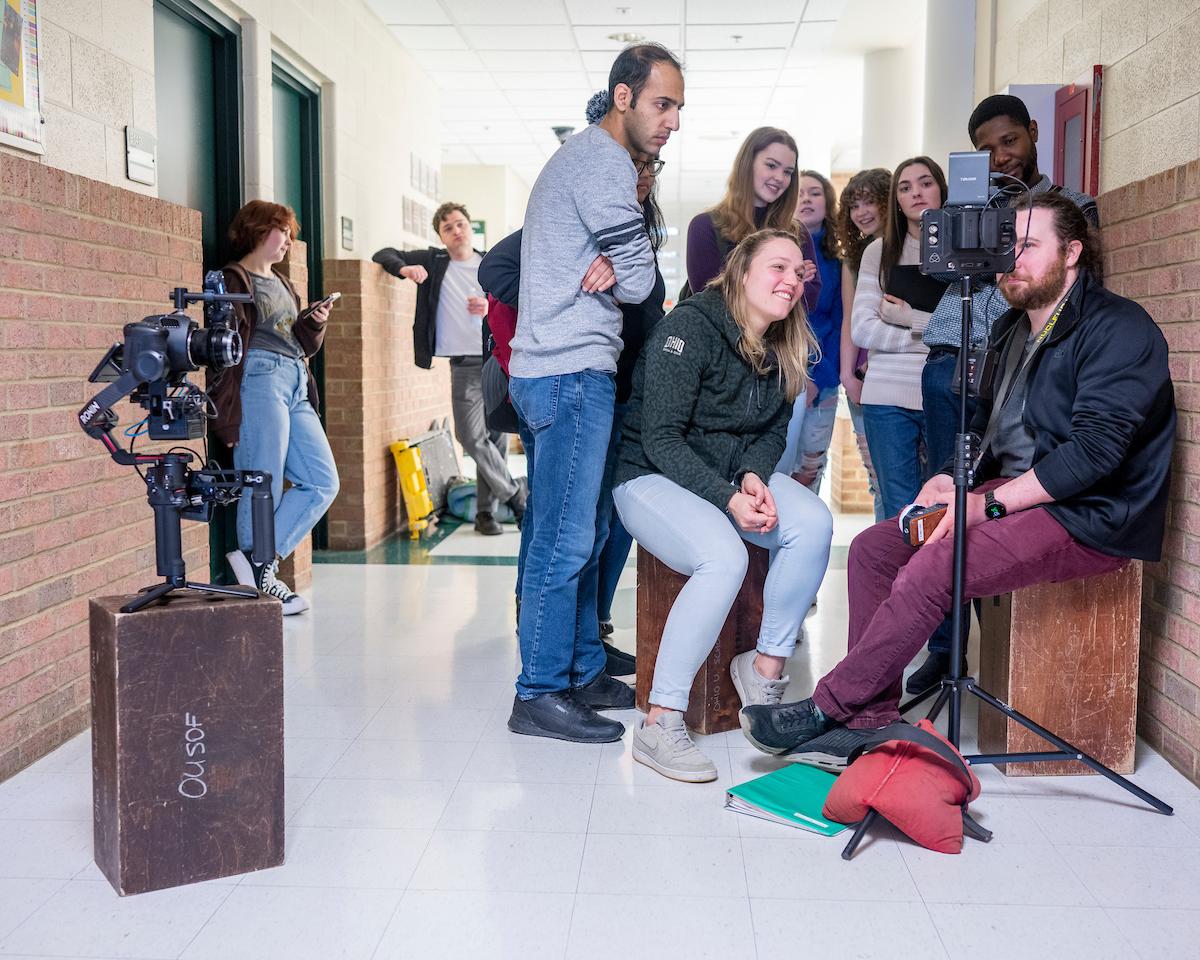 Group of film students on set reviewing a scene they just shot