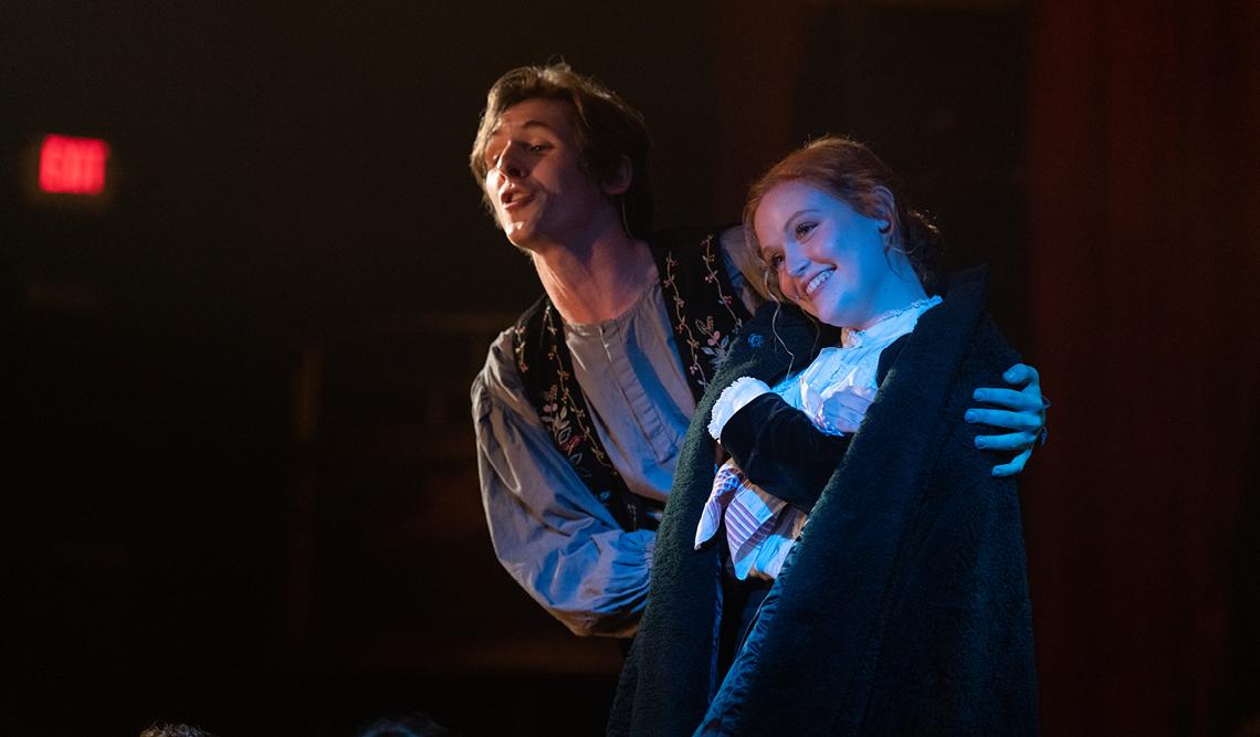 Two people embracing on stage