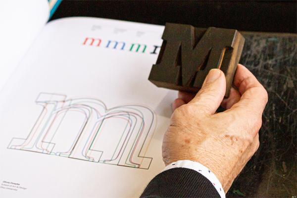 A 3-D "M" next to a drawing of  how to make it