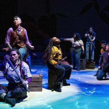 7 people on stage during a play performance