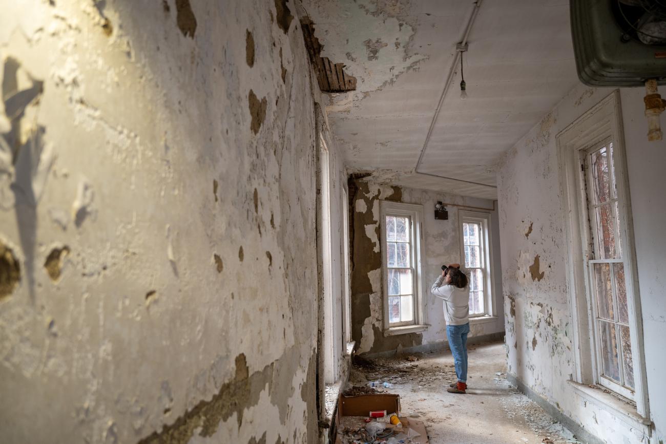 woman with a camera taking pictures in an abandoned building