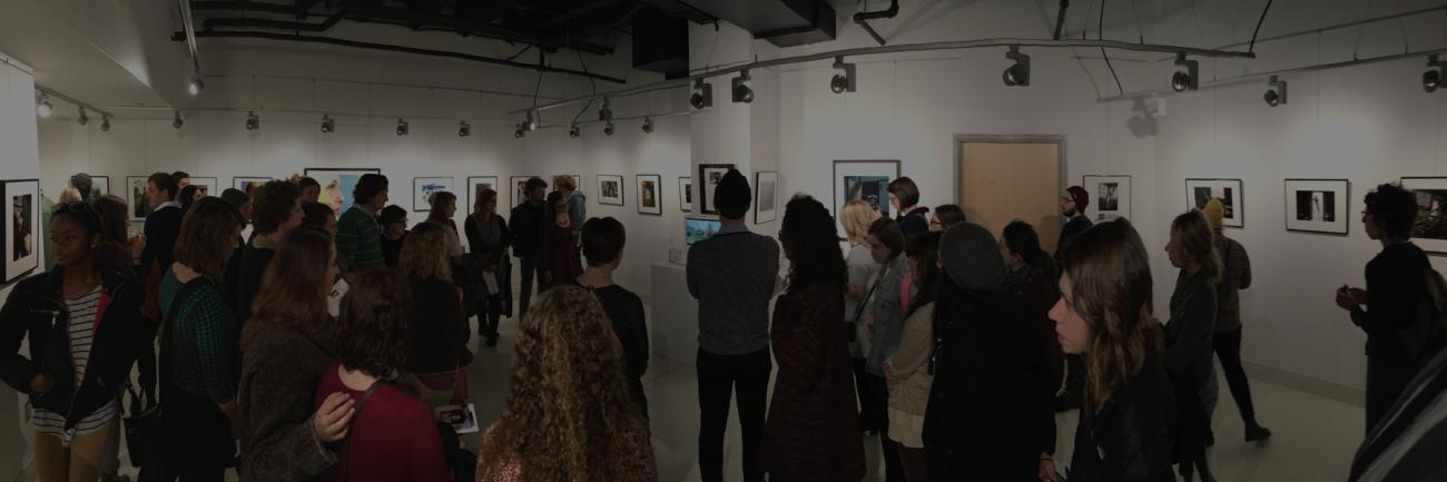 A crowd of students and faculty at a Visual Communication exhibit