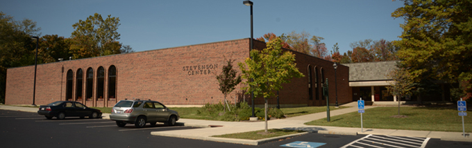 A brick building with a few large, windows with rounded corners.