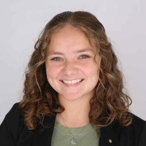 Headshot of Natalie Tolliver in a dark suit with light green top