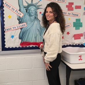 Image of Brea Kotts standing in front of classroom decor
