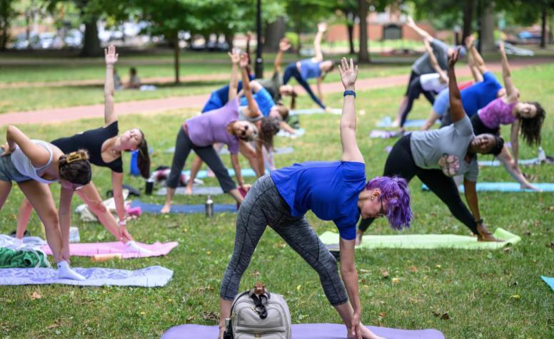 People performing yoga on the College Green