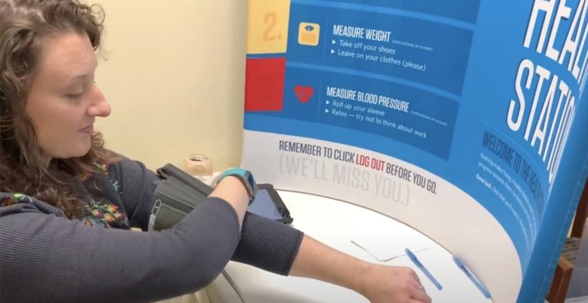 Employee taking their blood pressure at the Personify Health Station