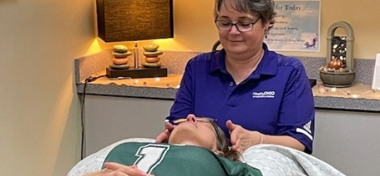 Reiki practitioner placing her hands near a client's head.