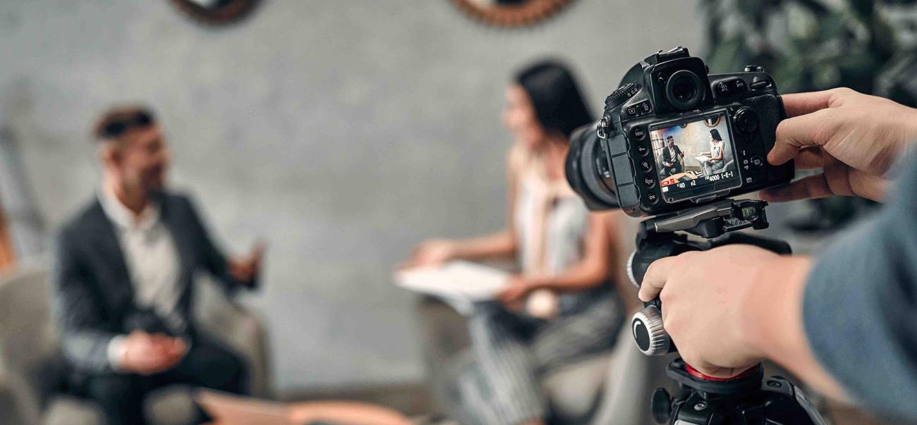 Close-up of a DSLR camera filming two people talking on set