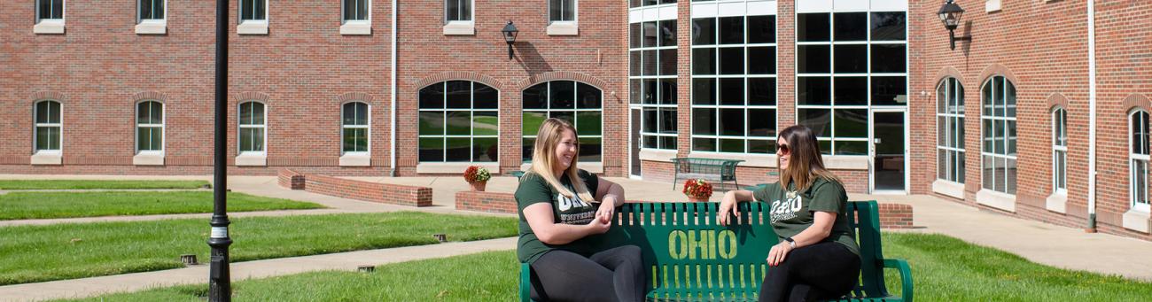Two OHIO Southern students sitting on a bench on the Southern campus