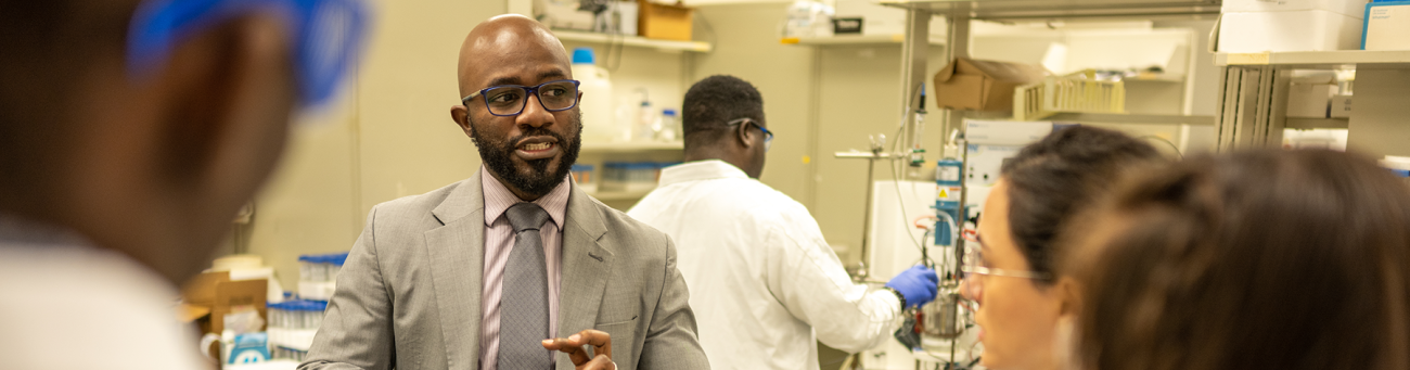 a professor lectures students in a science lab