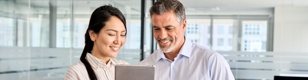two people standing looking at a notebook