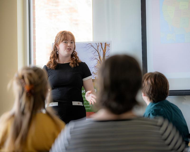 woman standing in front of a group giving a presentation