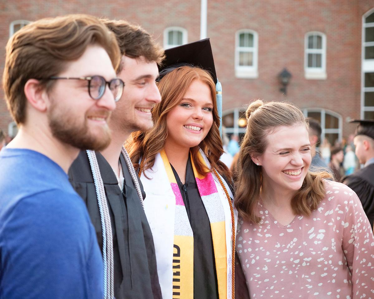 Graduate posing with family and friends