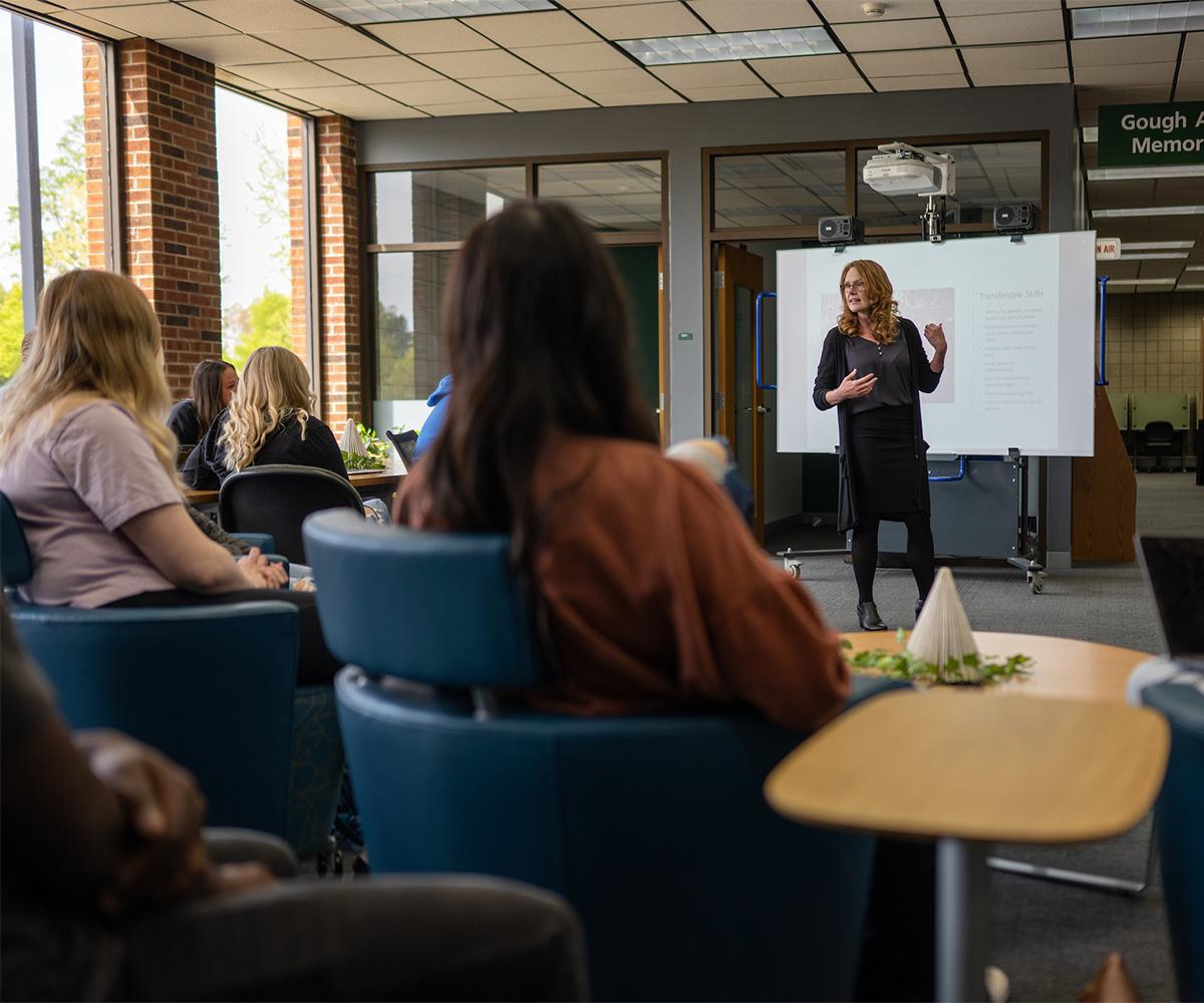 An instructor teaches in front of a classroom.