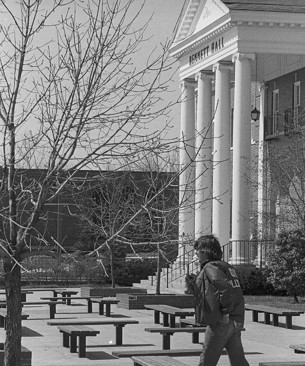 A student walks in front of Bennett Hall in 1976.