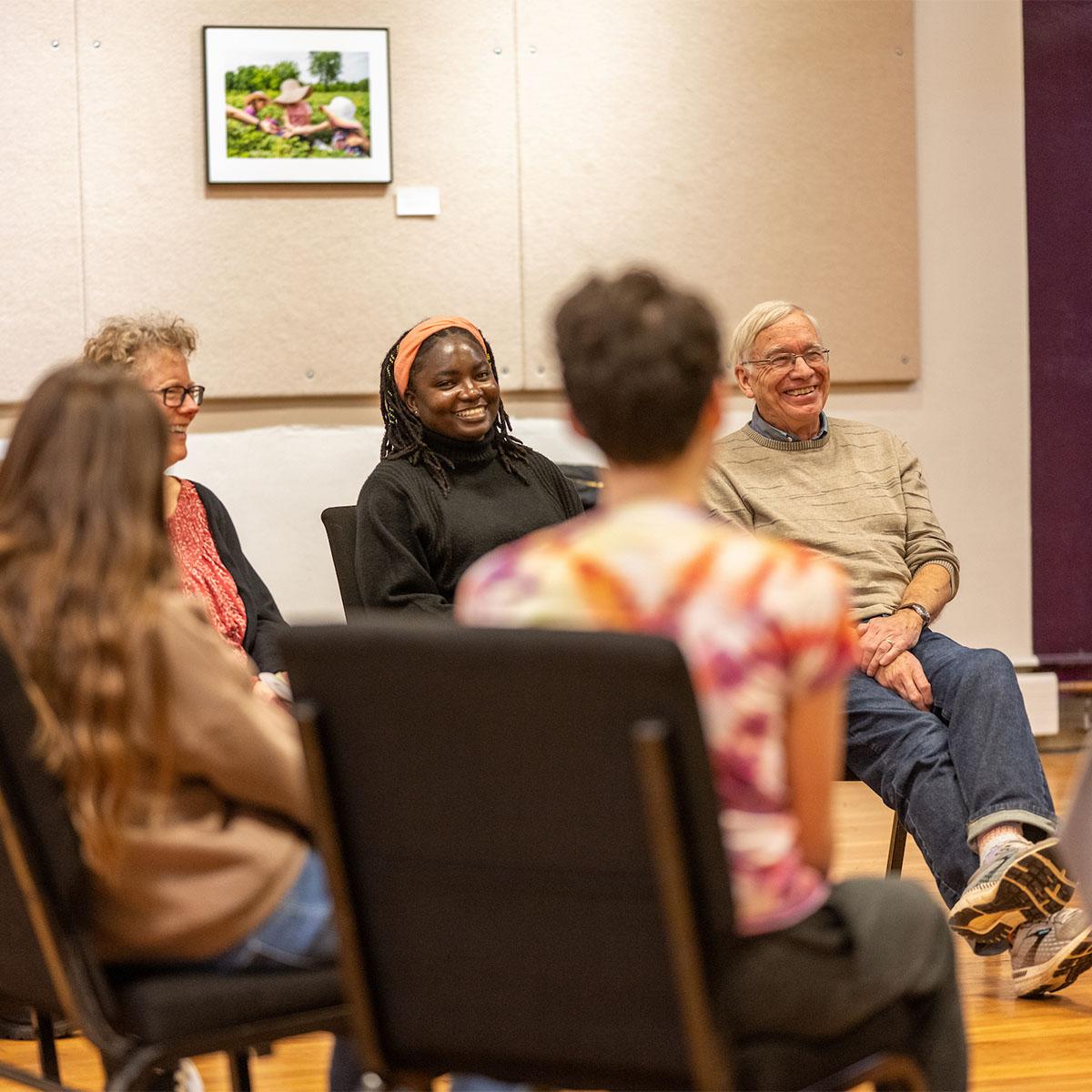 People sit in a circle and talk during a conference.