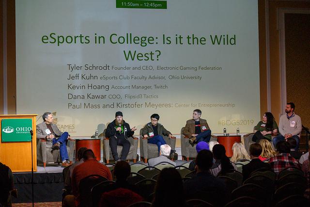 A group of people onstage participating in a panel discussion