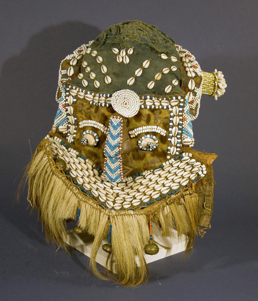 Kuba Moshambwooy (or Mukenga) Mask,  20th c. Kuba, Democratic Republic of Congo, bells, glass, fur, hair, wood, plant, 13 x 10 x 12.5in (33 x 25.4 x 31.75cm) 84.025.B6.