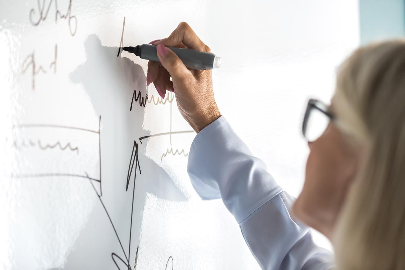 Person writing on a white board