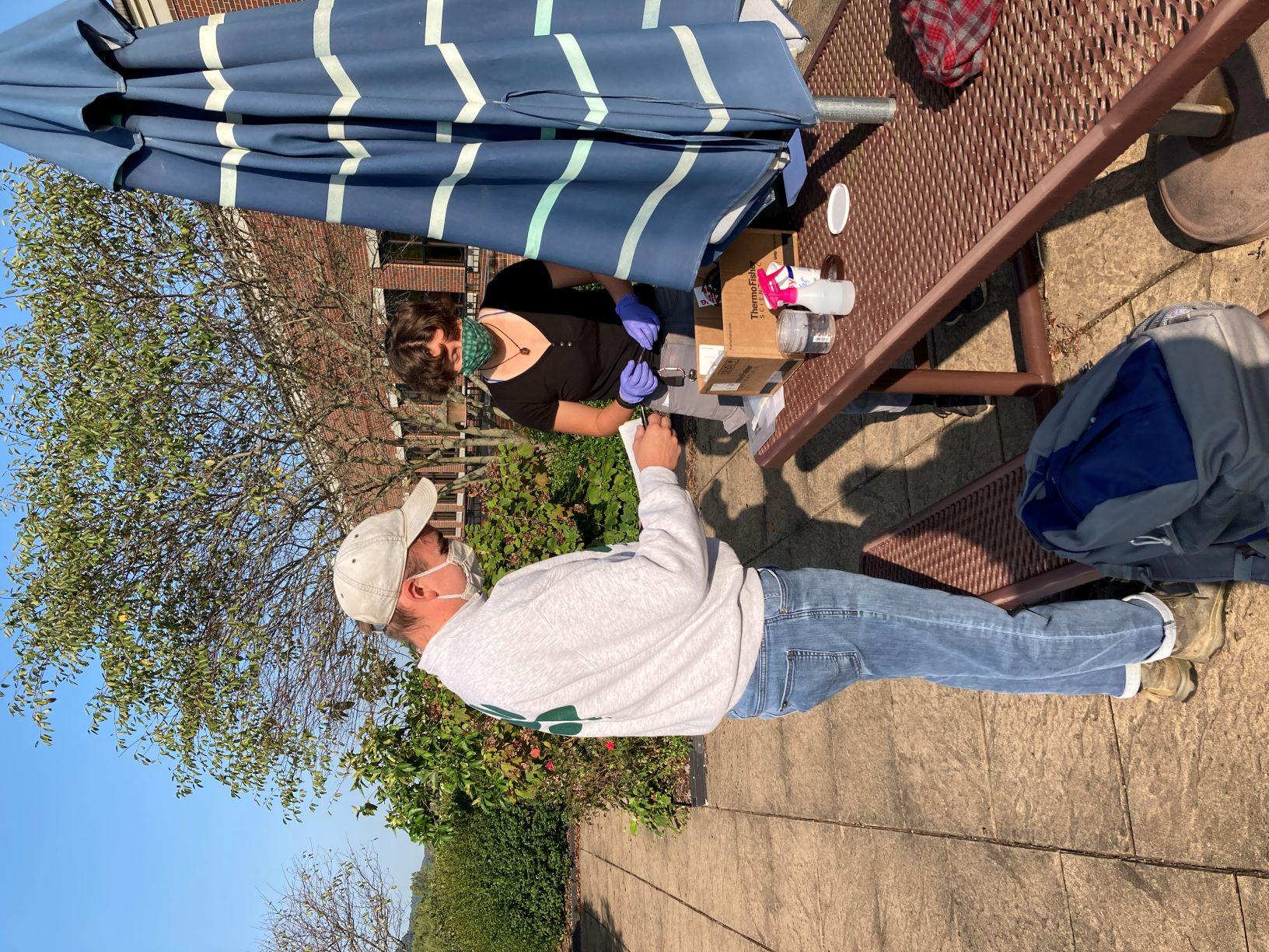 Photo of two students sampling on a roof