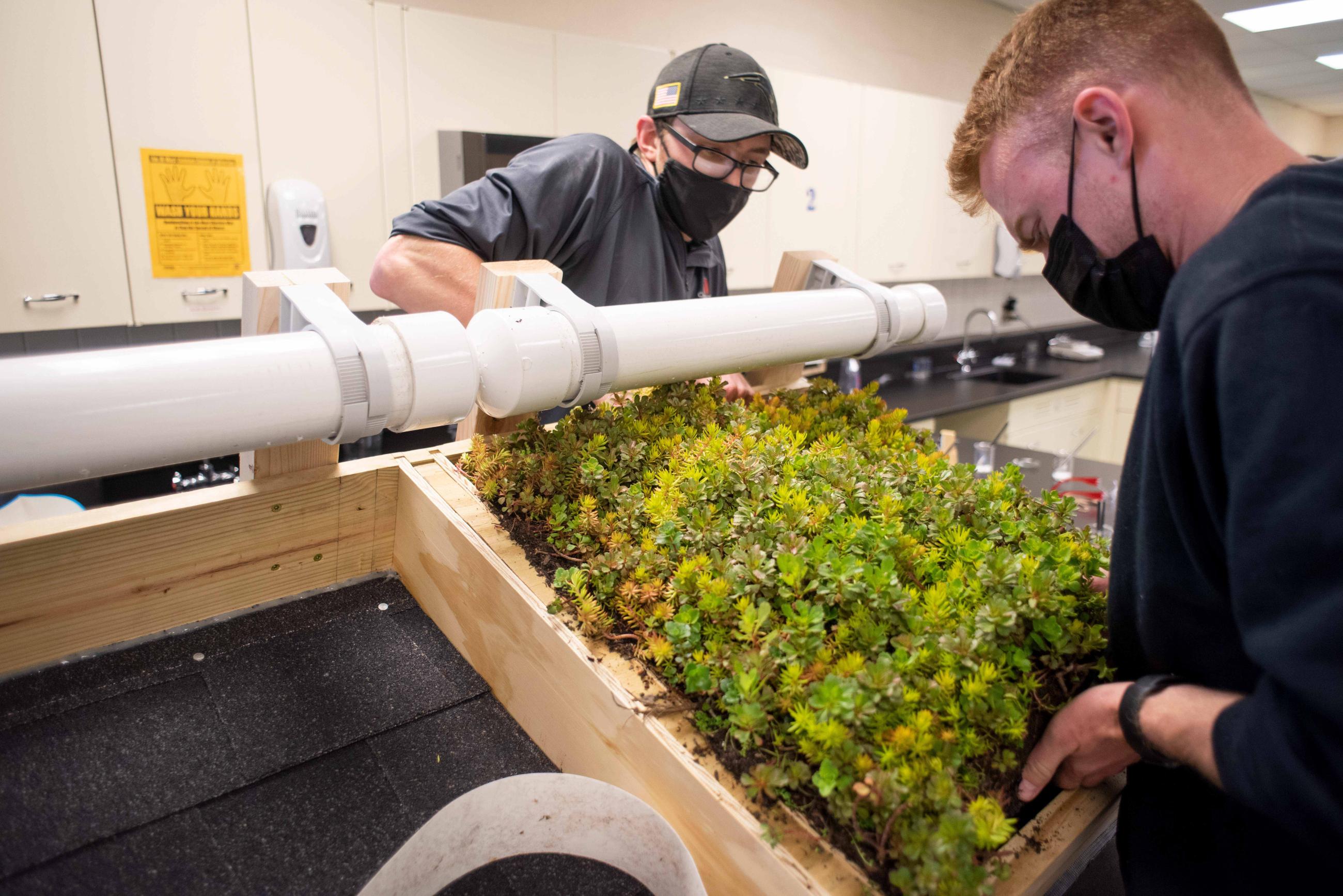 Students install a green roof model at Athens High School.