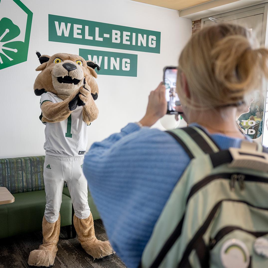 A student takes a photo of OHIO's mascot, Rufus the Bobcat.