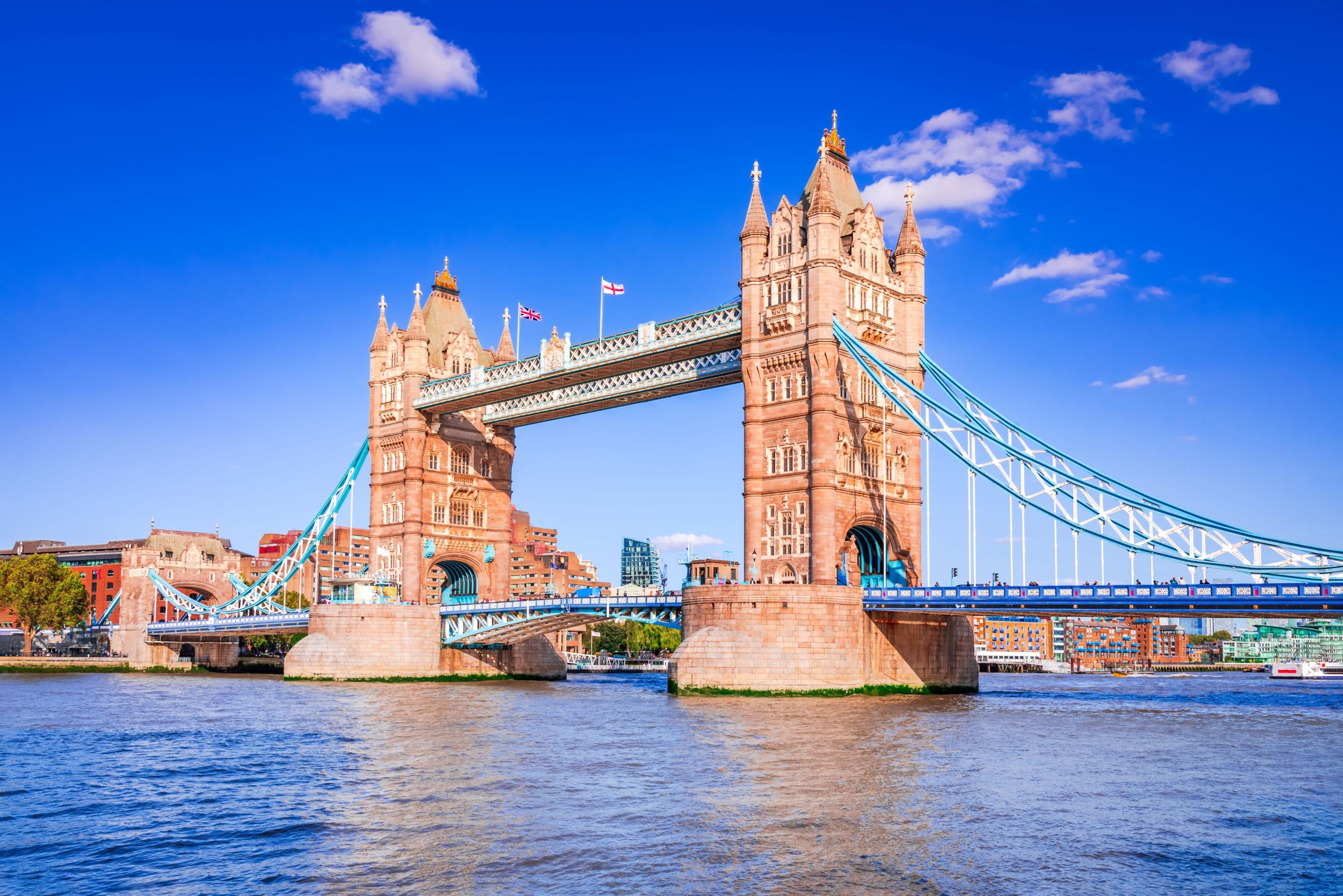 The tower bridge pictured against a blue sky with a few cloads floating behind