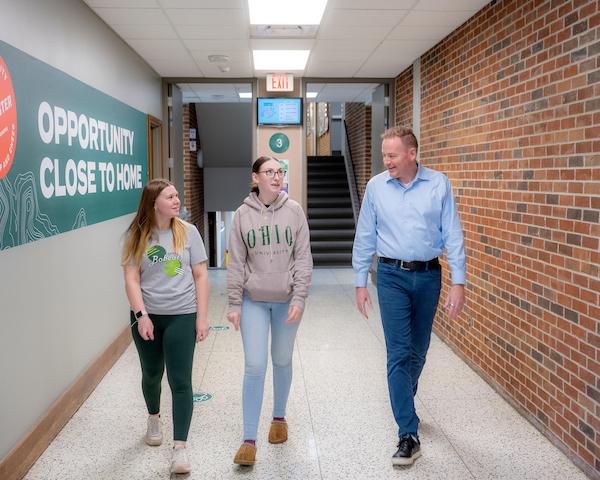 Professor walking with students in Brasee Hall