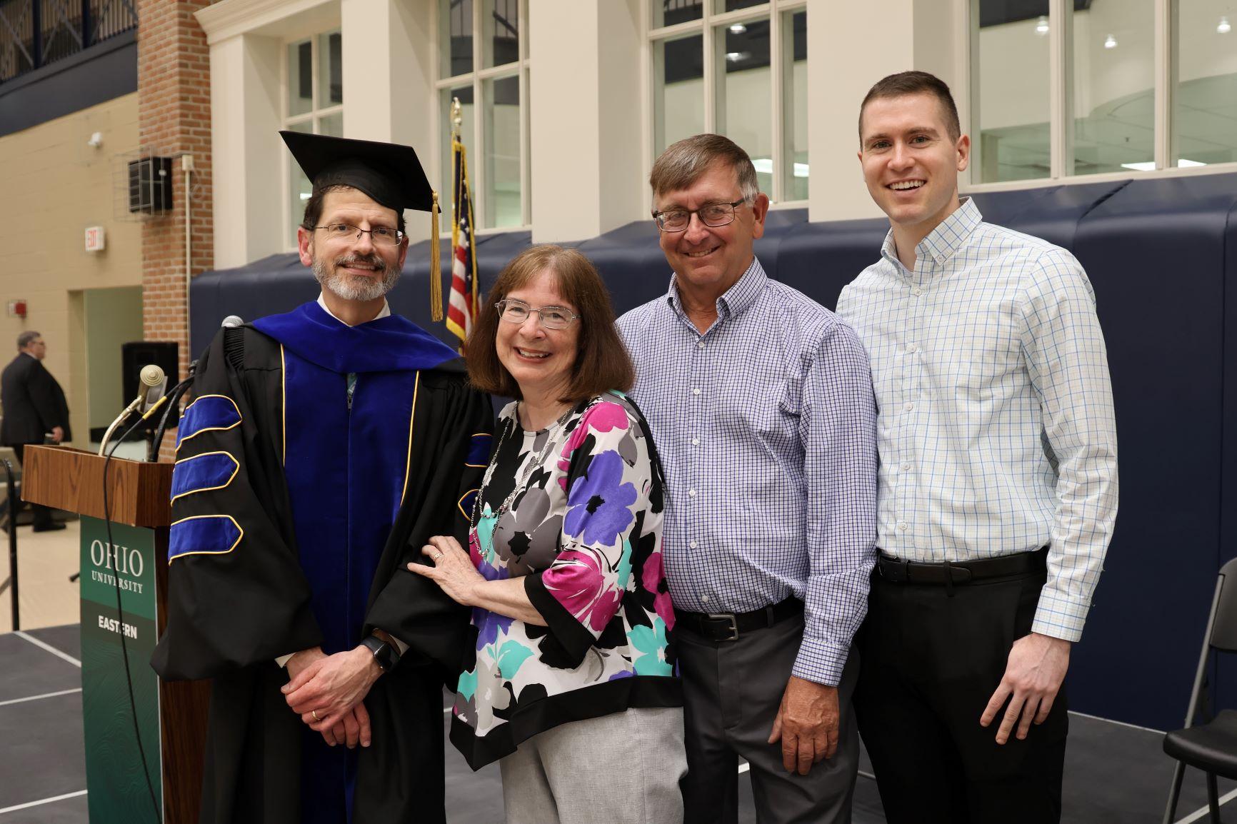 Group of individuals smiling at graduation ceremony
