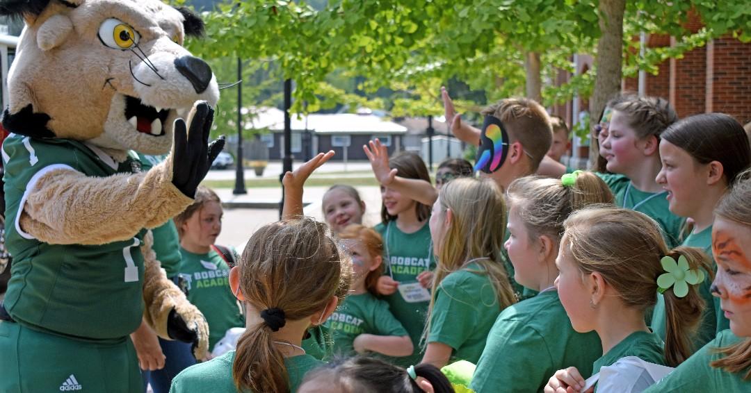 Kids high fiving Rufus mascot