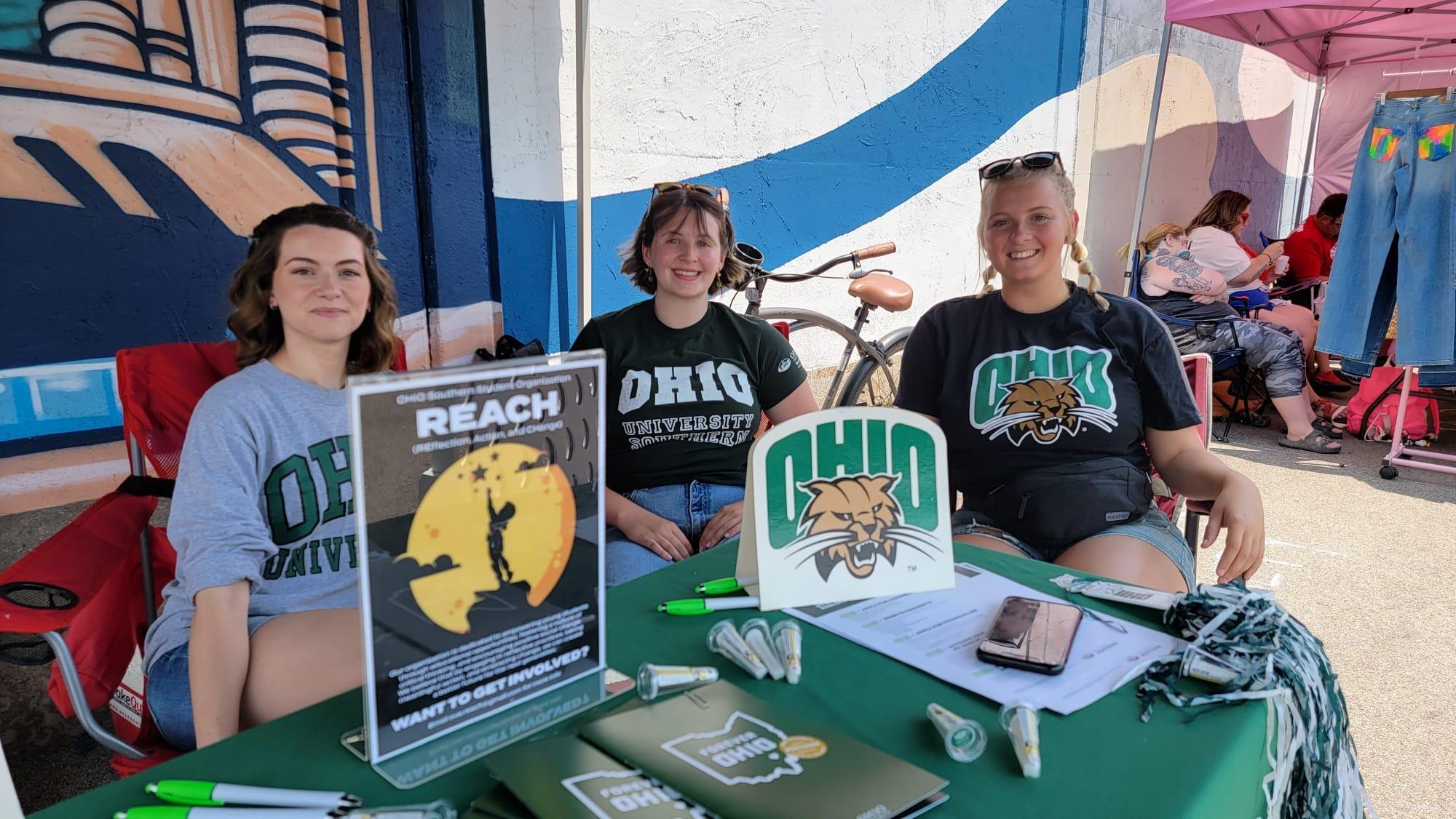 Students sitting behind table outdoors