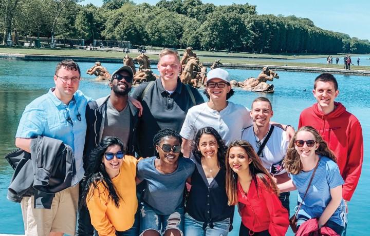 Group photo in front of water in background.