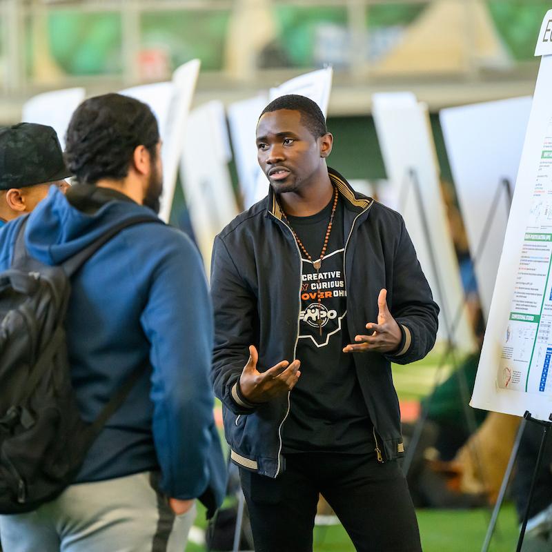 student presenting research during student expo